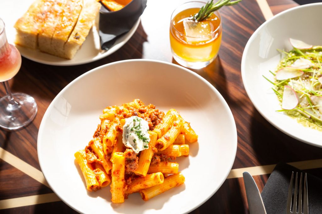 A plate of bolognese among other food on a table at Copper & Salt Northwest Kitchen