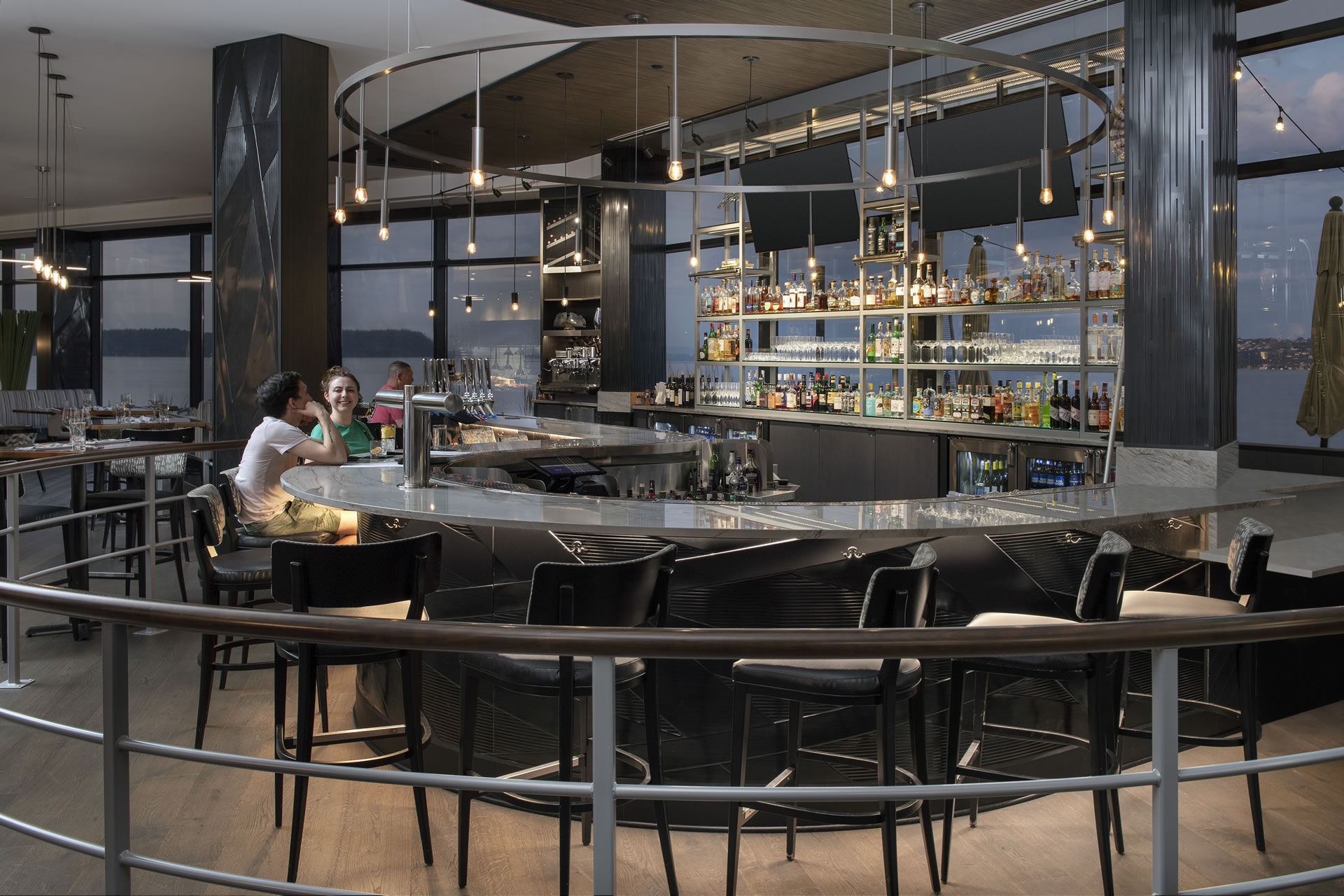 Two customers sitting at the bar of Copper & Salt Northwest Kitchen at Silver Cloud Point Ruston.